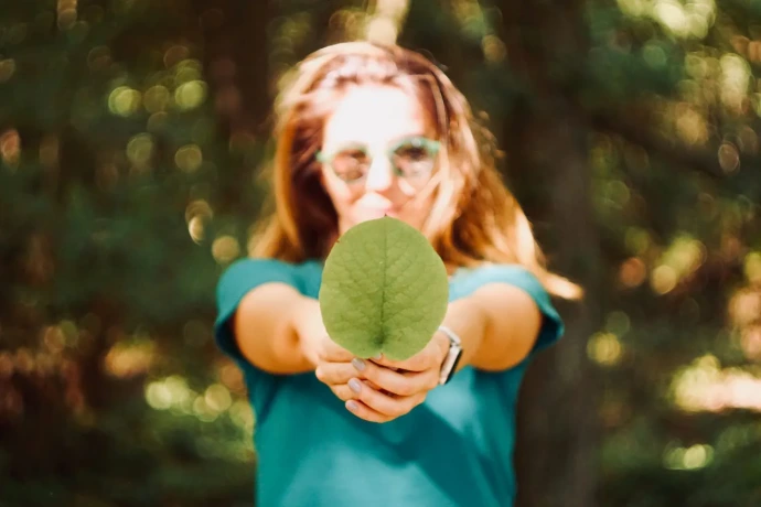 Woman holding a green leaf representing sustainable social enterprise initiatives